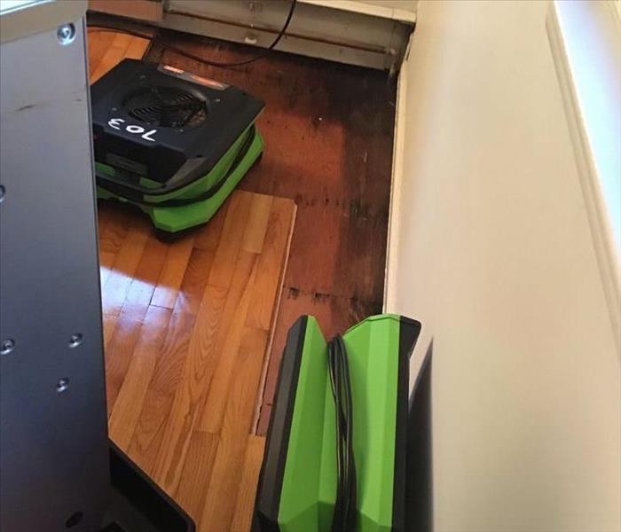 Water drying equipment on the hardwood floor where flood waters damaged the floor