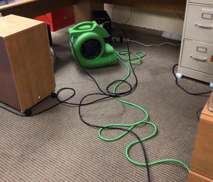 Carpeting and desk area shows water damage in an office building
