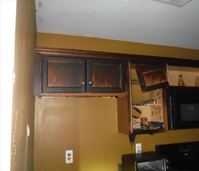 Kitchen shows fire and smoke damage on cabinets and walls.